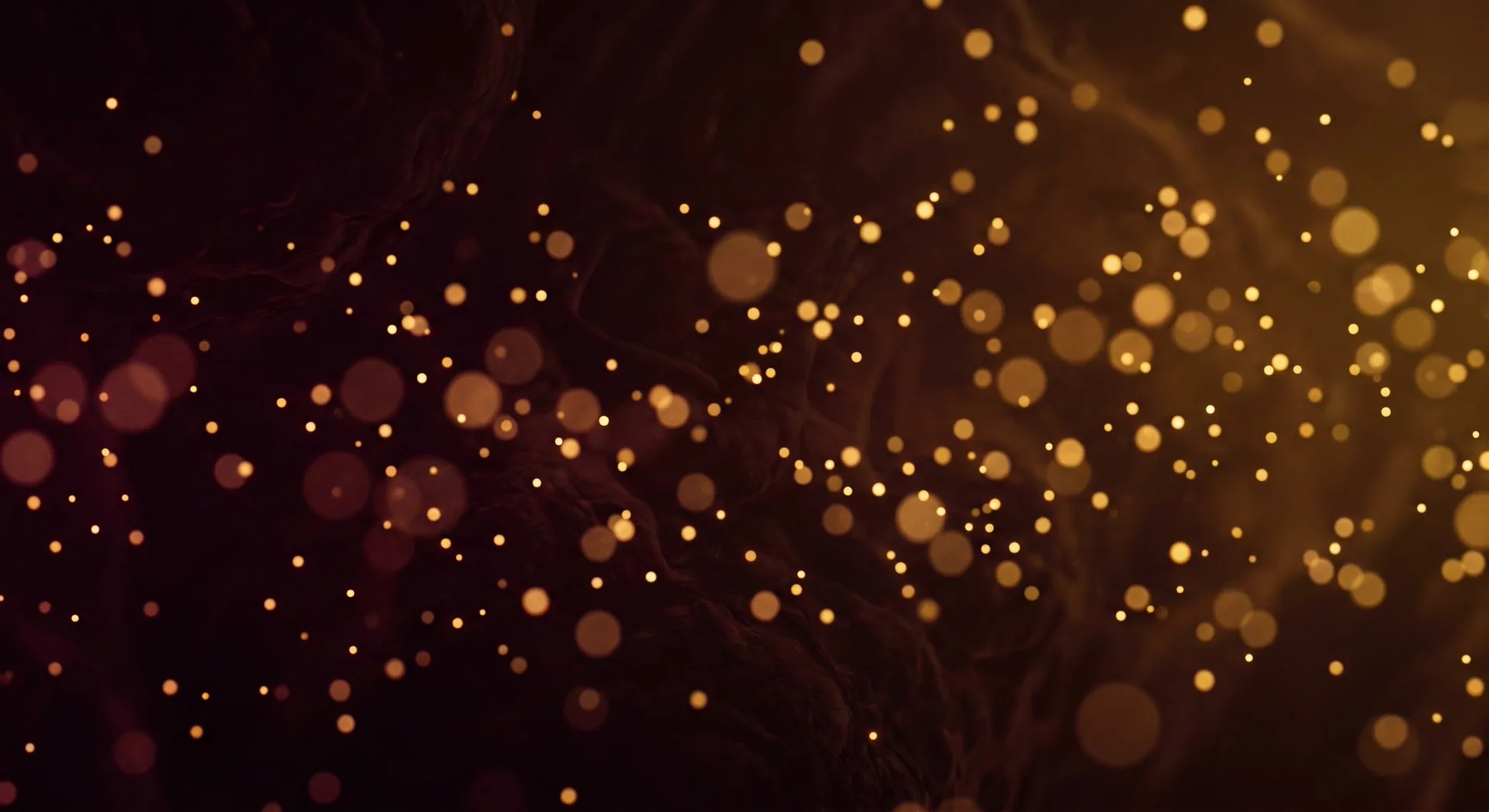 Abstract golden light particles floating through dark background evoking cellular energy